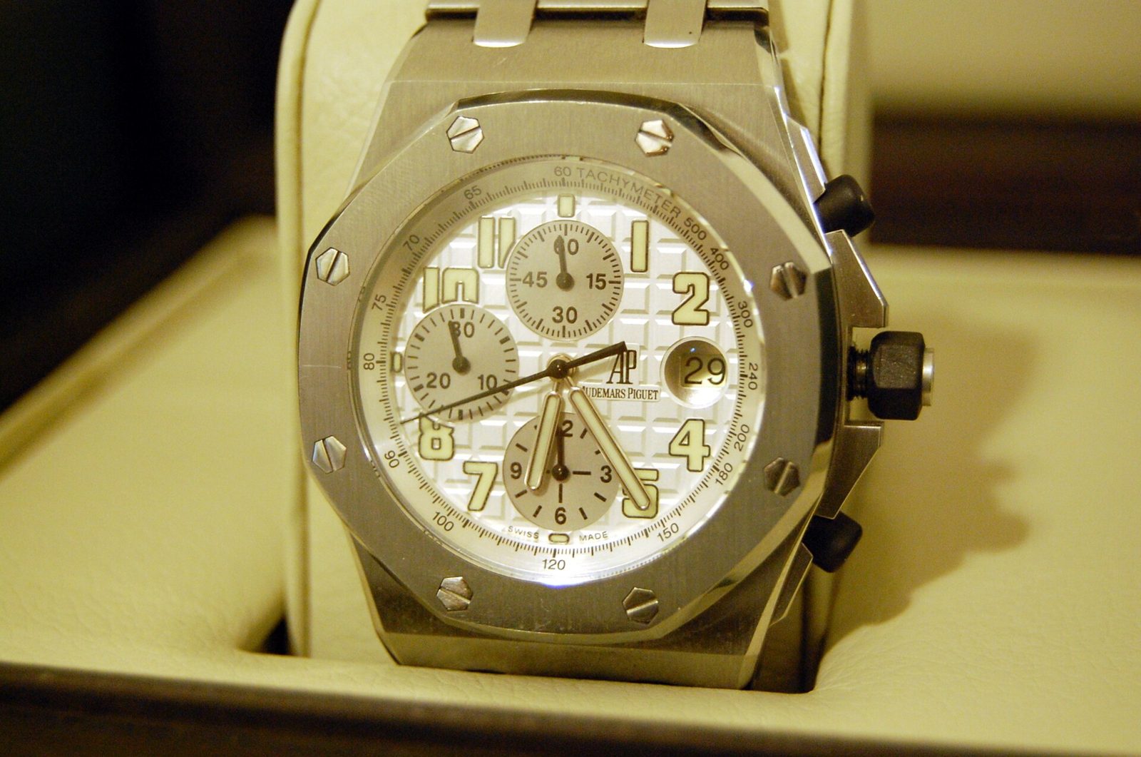 Stahl-Chronograph Royal Oak Offshore mit weissem Zifferblatt, drei Hilfszifferblättern und achteckiger Lünette mit sichtbaren Schrauben in einer hellen Uhrenbox