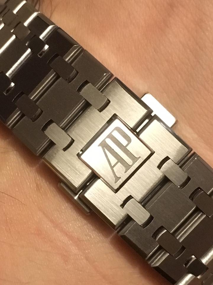Nahaufnahme des gebürsteten Stahlarmbands einer Royal Oak am Handgelenk, auf der Schliesse das Zeichen von Audemars Piguet