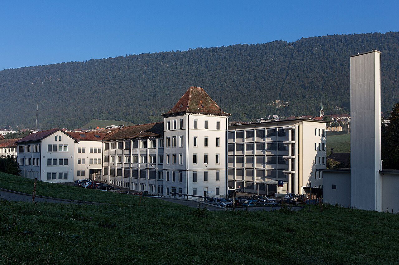 Gesamtansicht der Longines-Fabrikgebäude im Tal von Saint-Imier am frühen Morgen