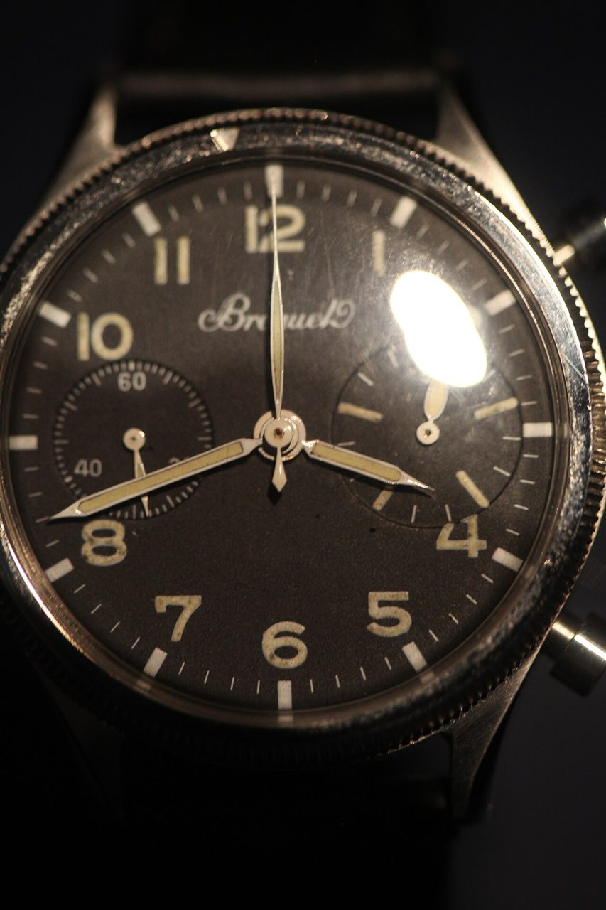 Nahaufnahme des schwarzen Zifferblatts mit arabischen Leuchtziffern, kleiner Sekunde bei 9 Uhr, Zähler bei 3 Uhr und dem Namenszug Breguet