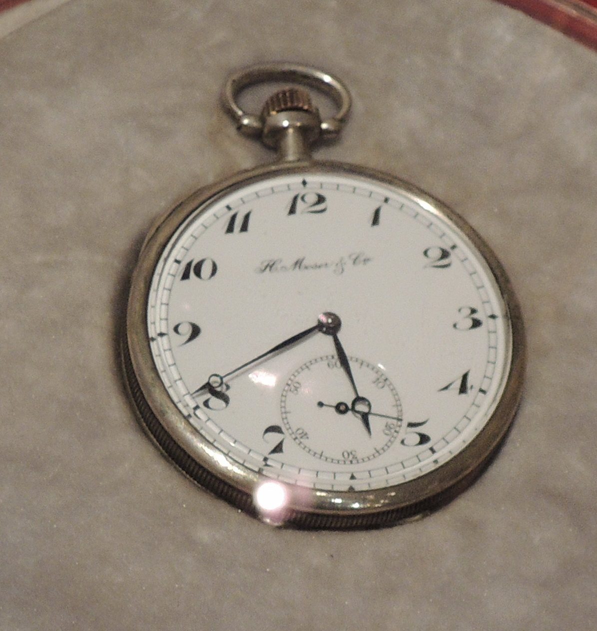 Silberne Taschenuhr mit weissem Zifferblatt, grossen schwarzen Ziffern, kleiner Sekunde bei 6 Uhr und der Aufschrift «H. Moser & Cie.»
