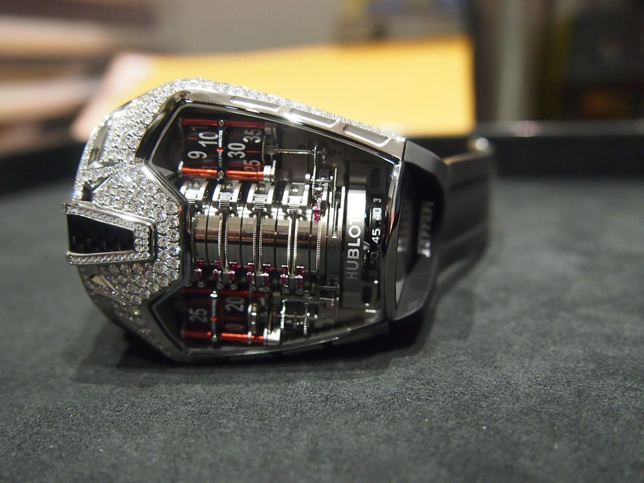 Hublot MP-05 LaFerrari mit diamantbesetztem Gehäuse und senkrecht angeordneten Gangreserve-Zylindern, seitlich auf dunkelgrünem Samt fotografiert.