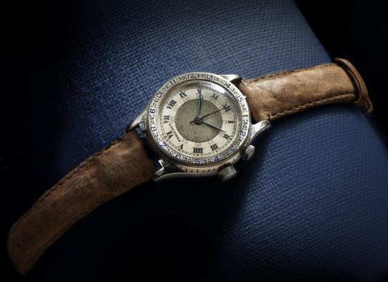 Alte Longines-Armbanduhr mit drehbarer Lünette, Gradeinteilung, römischen Ziffern und zwei Kronen auf braunem Lederband