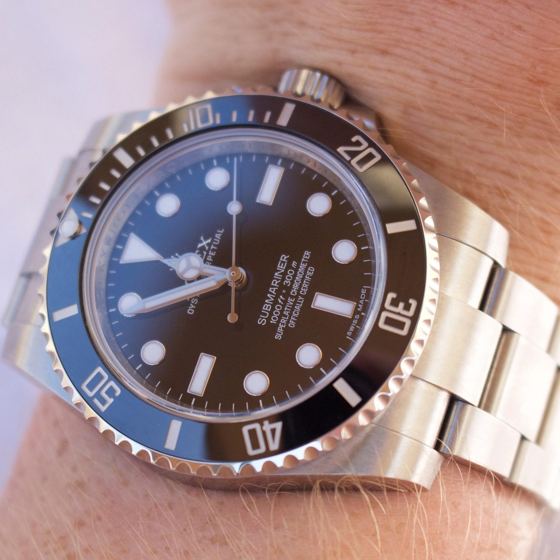 Rolex Submariner mit schwarzem Zifferblatt und Lünette in Nahaufnahme am Handgelenk