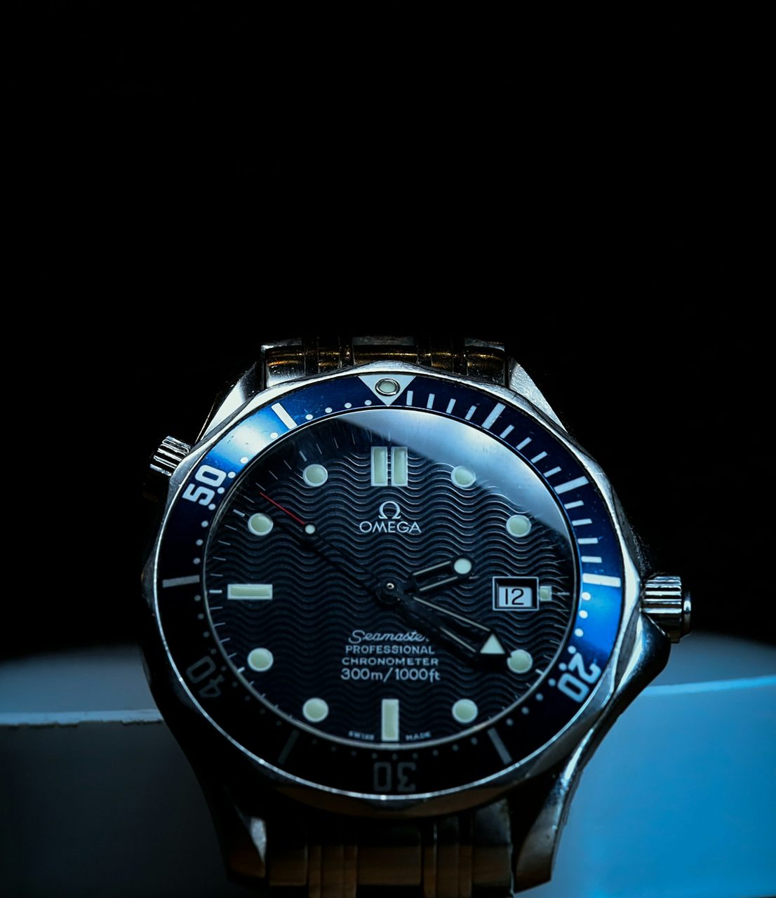 Omega Seamaster Diver 300M mit blauer Lünette und blauem Zifferblatt vor dunklem Hintergrund