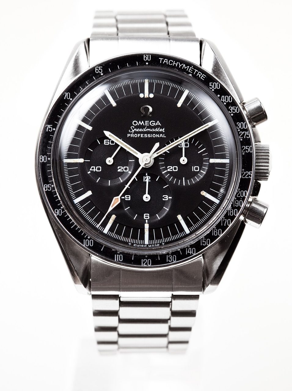 Frontale Nahaufnahme einer Omega Speedmaster Professional mit schwarzem Zifferblatt, Tachymeter-Lünette und Stahlband auf weissem Hintergrund.