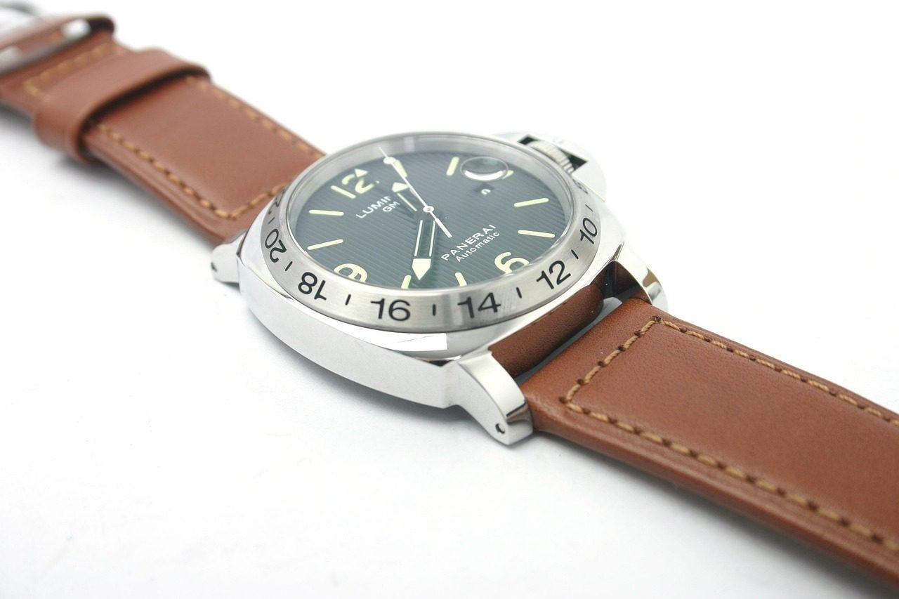 Panerai-Uhr mit schwarzem Zifferblatt und braunem Lederband auf weissem Grund, leicht von der Seite