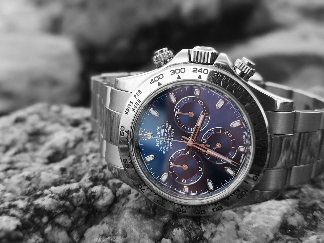 Rolex Cosmograph Daytona mit blauem Zifferblatt auf einem Felsen, Hintergrund schwarz-weiss