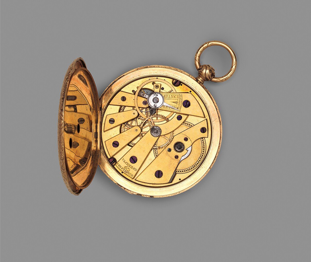 Geöffnete goldene Taschenuhr mit sichtbarem Messingwerk, das den Namenszug von Vacheron Constantin trägt, vor grauem Hintergrund